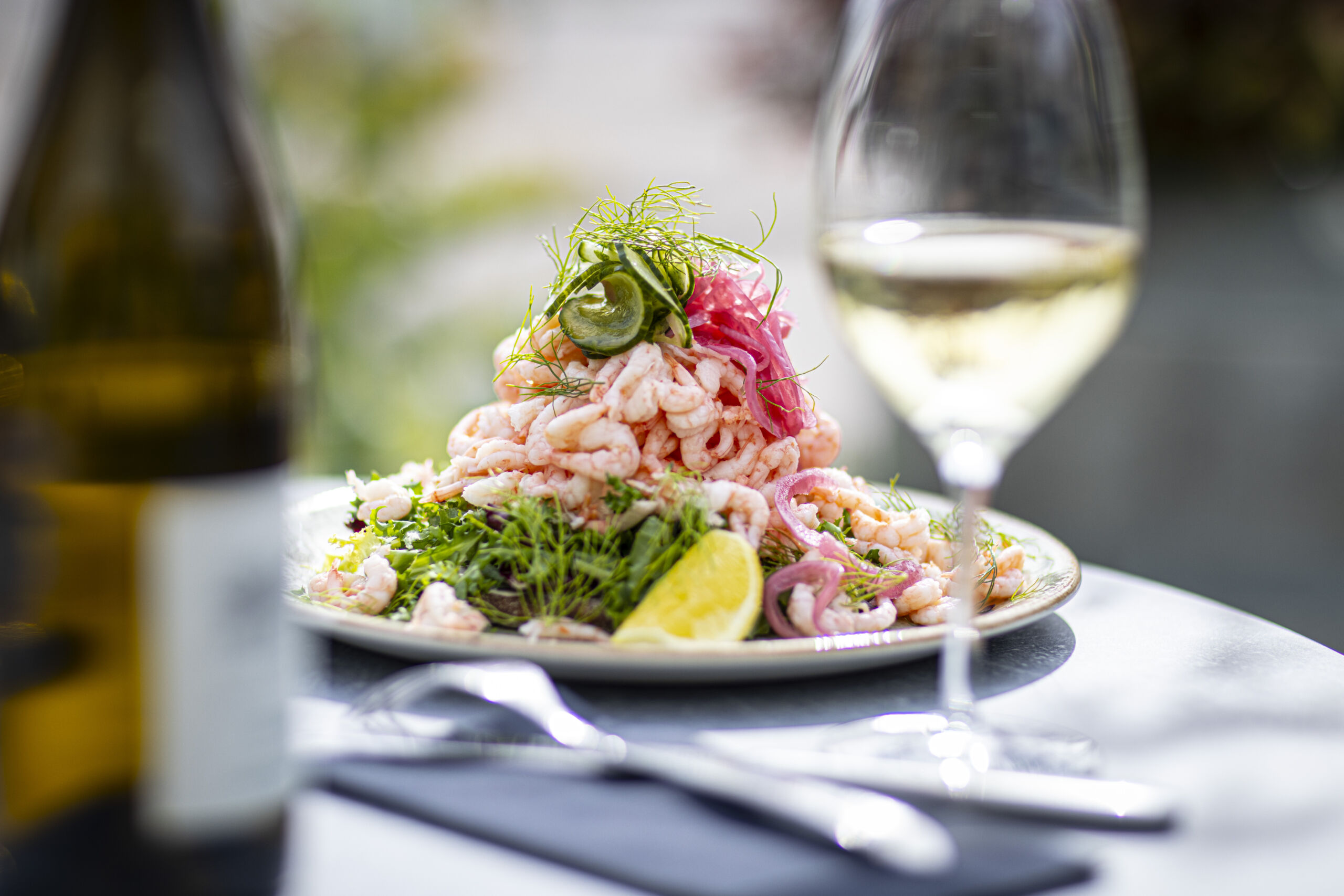 King Size shrimp sandwich with hand-peeled shrimp, dill and lemon, served on a plate.