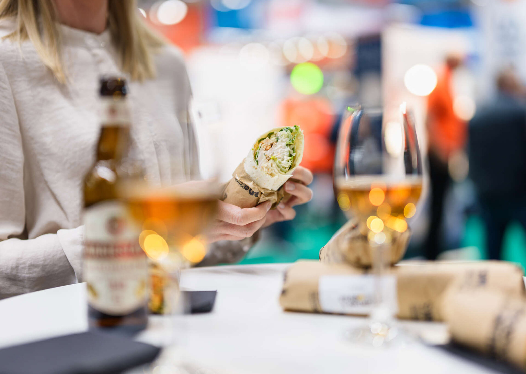 Meal with a wrap and drinks in an exhibition setting.